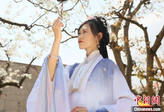 圖為蘭州青年身穿漢服在百年梨園賞景?！「哒?攝