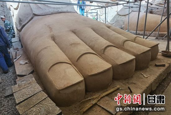 圖為中國“石窟鼻祖”天梯山石窟第13窟大佛足部與局部危巖體搶救性保護項目施工現(xiàn)場。陳曉斌 攝