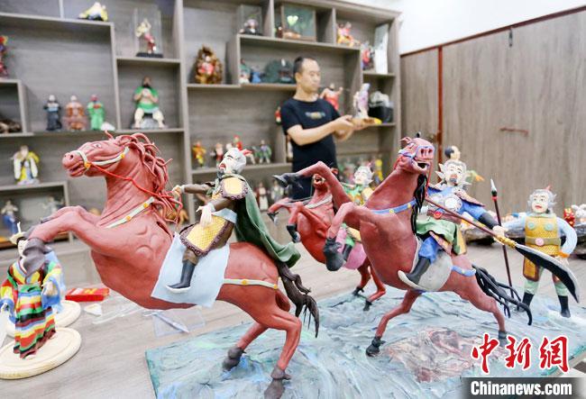 安秋平是成州面塑第五代傳承人，也是當?shù)匚ㄒ粓允孛嫠苤谱鞯娜??！「哒?攝