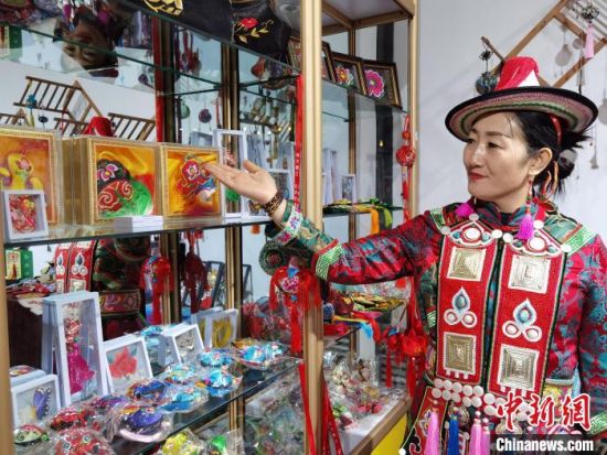 圖為身著民族服飾的隴原巧手展示手工藝品。(資料圖) 徐雪 攝