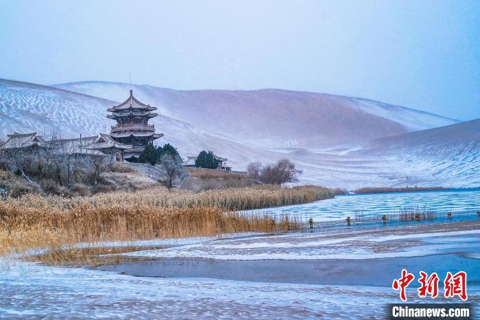 2021年11月28日，雪落鳴沙山月牙泉景區(qū)?！⊥醣筱y 攝