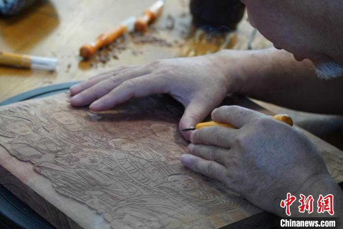 圖為徐晉林湊近木板，近距離制作雕版畫?！【琶赖┰?　攝