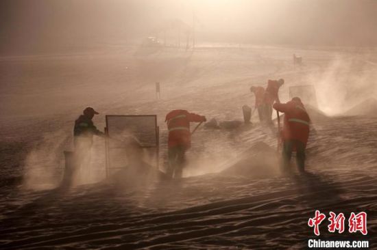 圖為敦煌市鳴沙山月牙泉景區(qū)“駱駝保姆”清理駱駝糞便。　張曉亮 攝