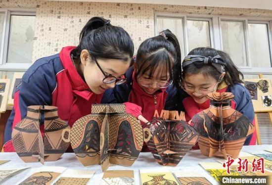 圖為學(xué)生用紙創(chuàng)作的立體彩陶?！⒂裉?攝