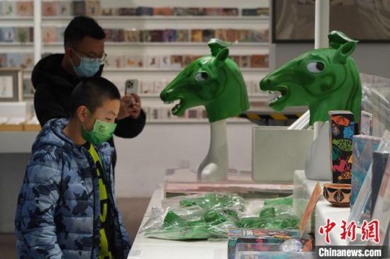 圖為“神馬來了”銅奔馬頭套吸引參觀者駐足?！【琶赖┰?攝