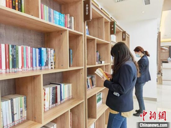 圖為在甘肅公航旅建設(shè)集團(tuán)有限公司的職工書屋，職工挑選書籍。　徐雪 攝
