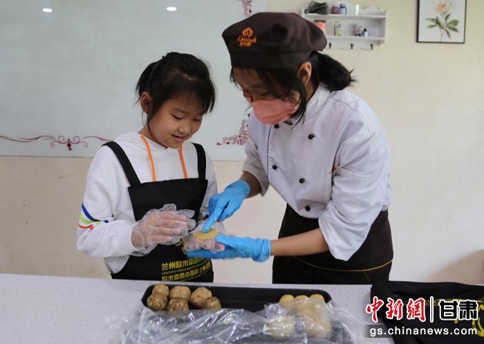 圖為在甘臺(tái)胞小朋友在工作人員指導(dǎo)下制作月餅。九美旦增 攝