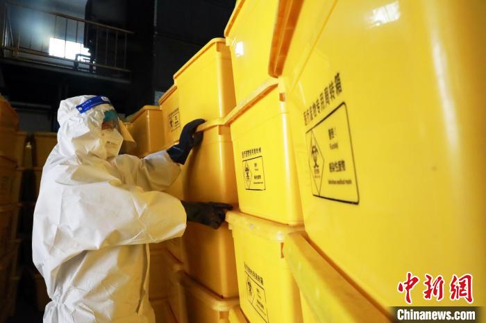 圖為工作人員搬運醫(yī)療廢物專用周轉(zhuǎn)箱?！∥航ㄜ?攝