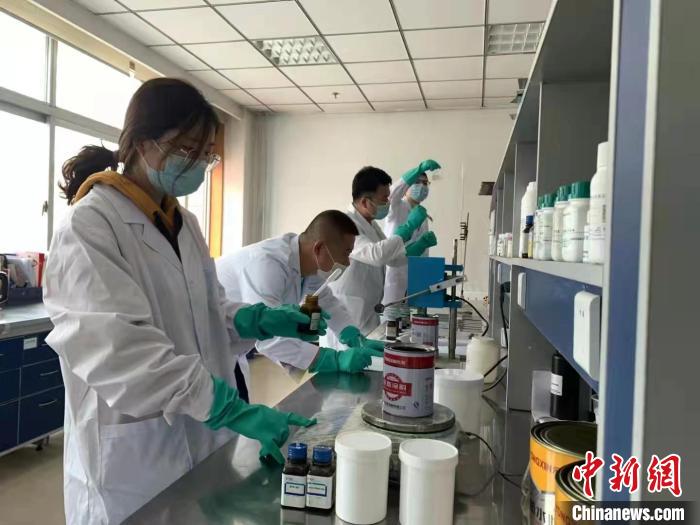 圖為肖菲(前一)帶領團隊研發(fā)水性涂料。(資料圖) 受訪者供圖