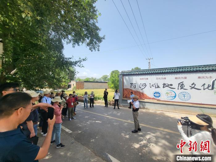 圖為中國地質(zhì)大學(xué)(北京)教授張緒教介紹村落情況。　胡友軍 攝