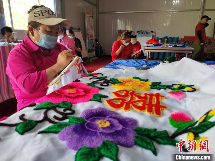 圖為婦女制作青繡?！?zhí)砀?攝