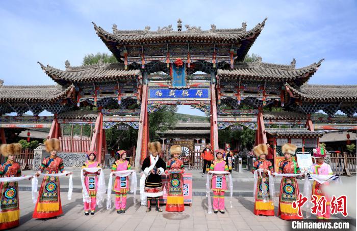 圖為身穿土族服飾的工作人員迎接訪客?！⊙Φ?攝