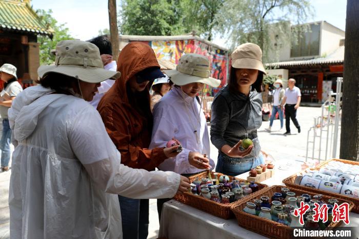 圖為民眾挑選手工藝產(chǎn)品?！⊙Φ?攝