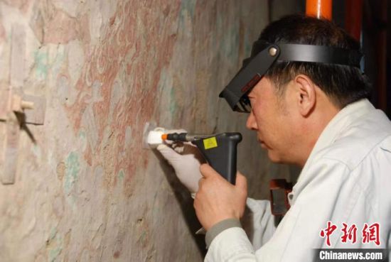 敦煌研究院研究員樊再軒進行壁畫修復(fù)。(資料圖)張云文 攝