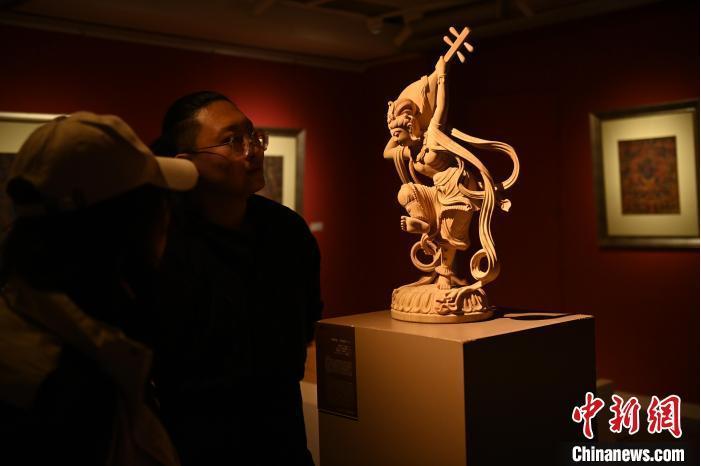 圖為季茂杰向參觀者介紹自己創(chuàng)作敦煌木雕的過(guò)程。李亞龍 攝</p>
<p>