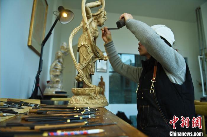 圖為季茂杰進(jìn)行敦煌元素的木雕創(chuàng)作。李亞龍 攝</p>
<p>