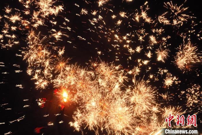 灼熱的鐵水在空中迸散。在空中形成“鐵花火雨”的景象，似天女散花，似群星漫天，如夢如幻，美不勝收。侯奇志 攝</p>
<p>