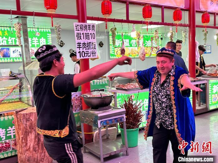 圖為餐飲經(jīng)營(yíng)者在“西涼不夜城”跳起舞蹈引客?！〈魑牟?攝</p><p>