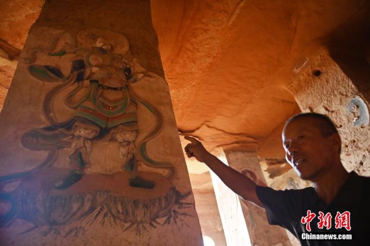 7月15日，甘肅省平?jīng)鍪袥艽h百里石窟長廊羅漢洞石窟內(nèi)，該窟文保員郭建平介紹窟內(nèi)石刻彩繪壁畫。郭建平家中三代人曾自發(fā)保護(hù)羅漢洞石窟。羅漢洞石窟遺存40余個窟龕，以北魏至清代風(fēng)格為主。中新社記者 李亞龍 攝</p>
<p>