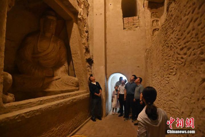 7月15日，游人參觀甘肅省平?jīng)鍪袥艽h百里石窟長廊中的王母宮石窟。百里石窟長廊位于涇川縣境內(nèi)，由512個石窟、5眼窟中石井組成，現(xiàn)存王母宮石窟、鳳凰山石窟、南石窟寺、丈八寺石窟、羅漢洞石窟、太山寺石窟等規(guī)模較大的石窟群，還有數(shù)量眾多的小石窟群。王母宮石窟又名千佛洞，該窟設(shè)計宏大，造像生動，窟內(nèi)擁有造像數(shù)百尊，是較為珍貴的佛教文化歷史遺存。中新社記者 李亞龍 攝</p>
<p>