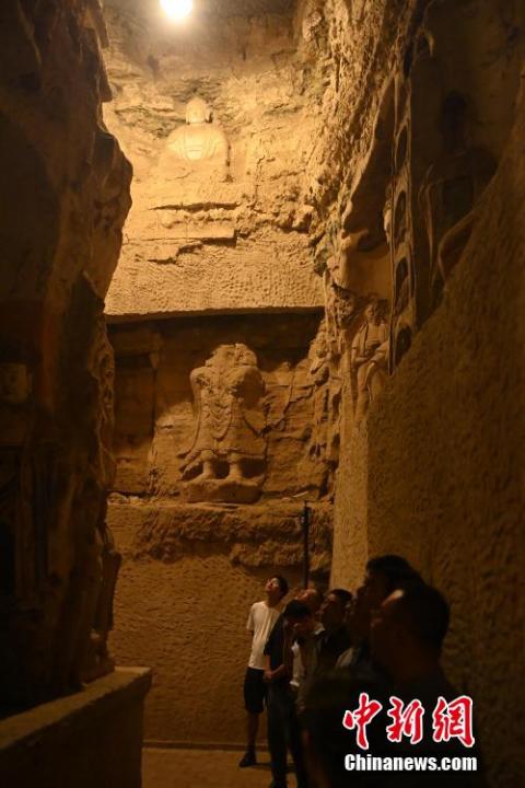 7月15日，游人參觀甘肅省平?jīng)鍪袥艽h百里石窟長廊中的王母宮石窟。百里石窟長廊位于涇川縣境內(nèi)，由512個石窟、5眼窟中石井組成，現(xiàn)存王母宮石窟、鳳凰山石窟、南石窟寺、丈八寺石窟、羅漢洞石窟、太山寺石窟等規(guī)模較大的石窟群，還有數(shù)量眾多的小石窟群。王母宮石窟又名千佛洞，該窟設(shè)計宏大，造像生動，窟內(nèi)擁有造像數(shù)百尊，是較為珍貴的佛教文化遺存。中新社記者 李亞龍 攝</p>
<p>