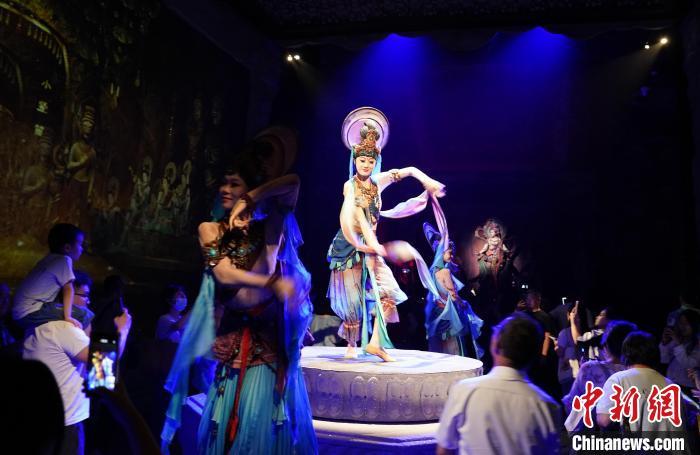 《樂動敦煌》是全球首部洞窟式沉浸體驗(yàn)劇，利用真人與數(shù)字影像虛實(shí)交換實(shí)現(xiàn)沉浸式體驗(yàn)。圖為2023年8月28日晚，《樂動敦煌》演出。(資料圖)中新社記者 毛建軍 攝