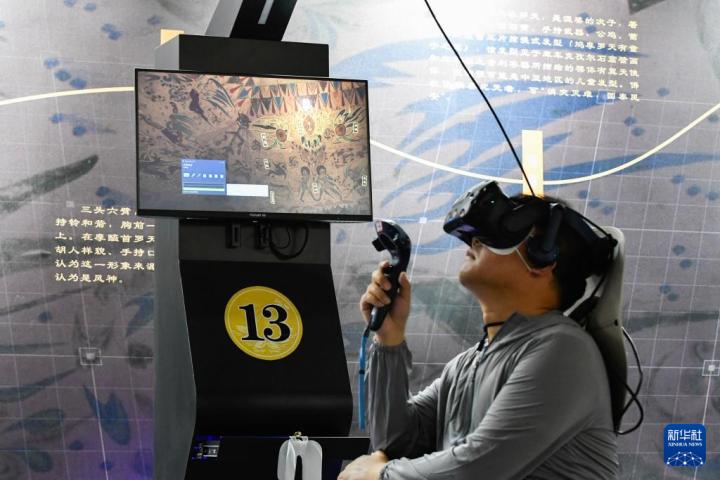 7月22日，游客借助VR設(shè)備沉浸式游覽莫高窟第285窟虛擬場景。新華社記者 郎兵兵 攝